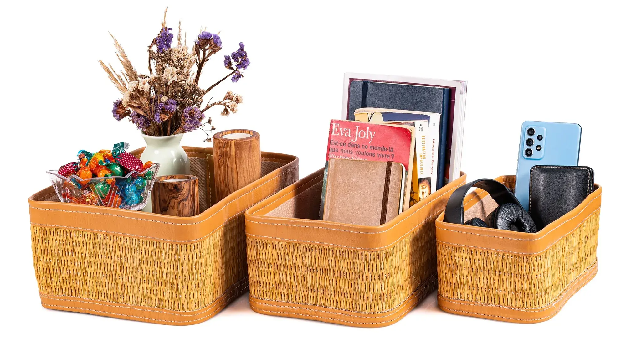 Set of 3 darido handmade natural fiber storage boxes with brown leather trim filled with office supplies and accessories.