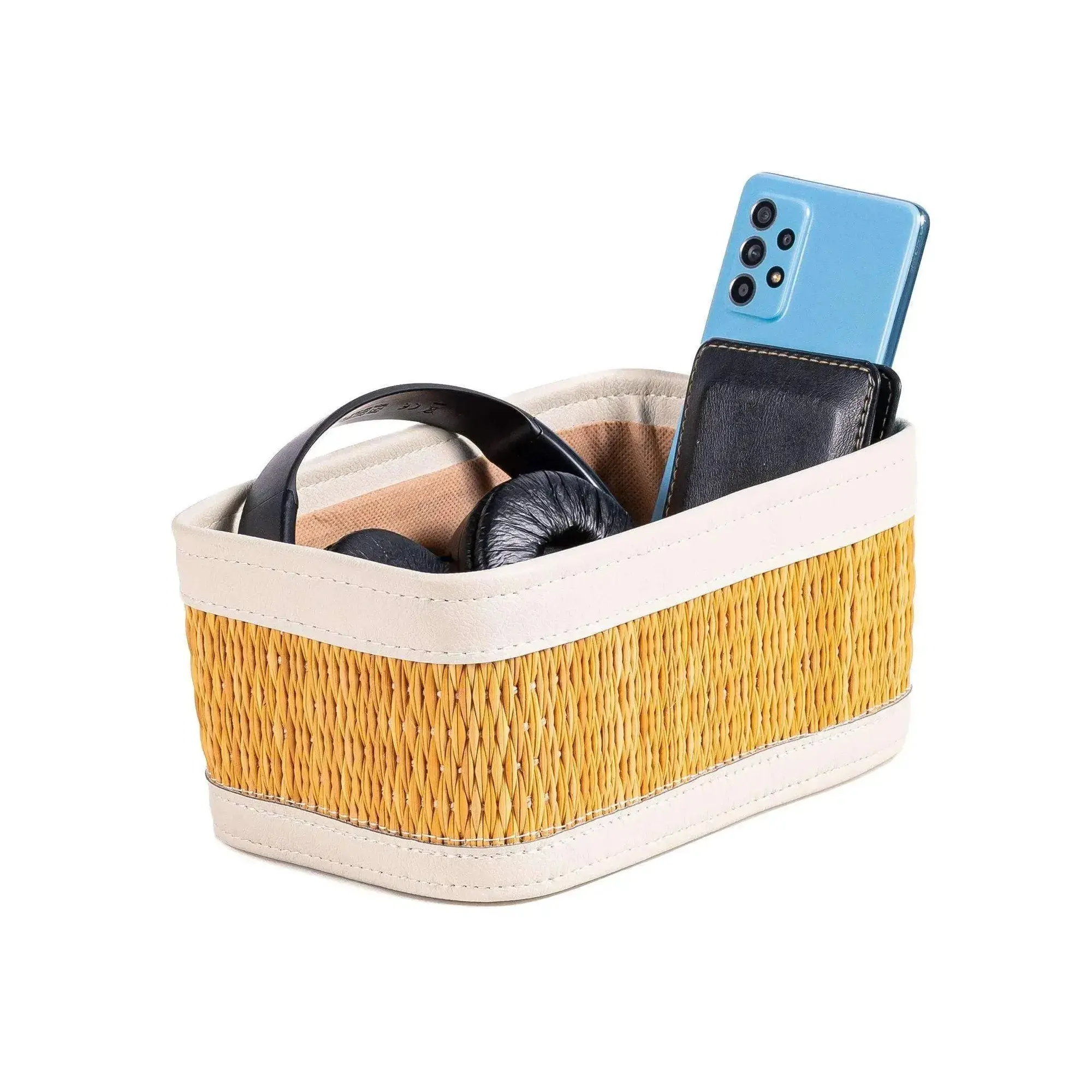 Small rectangular darido storage box with woven yellow exterior and beige trim holding headphones and a phone.
