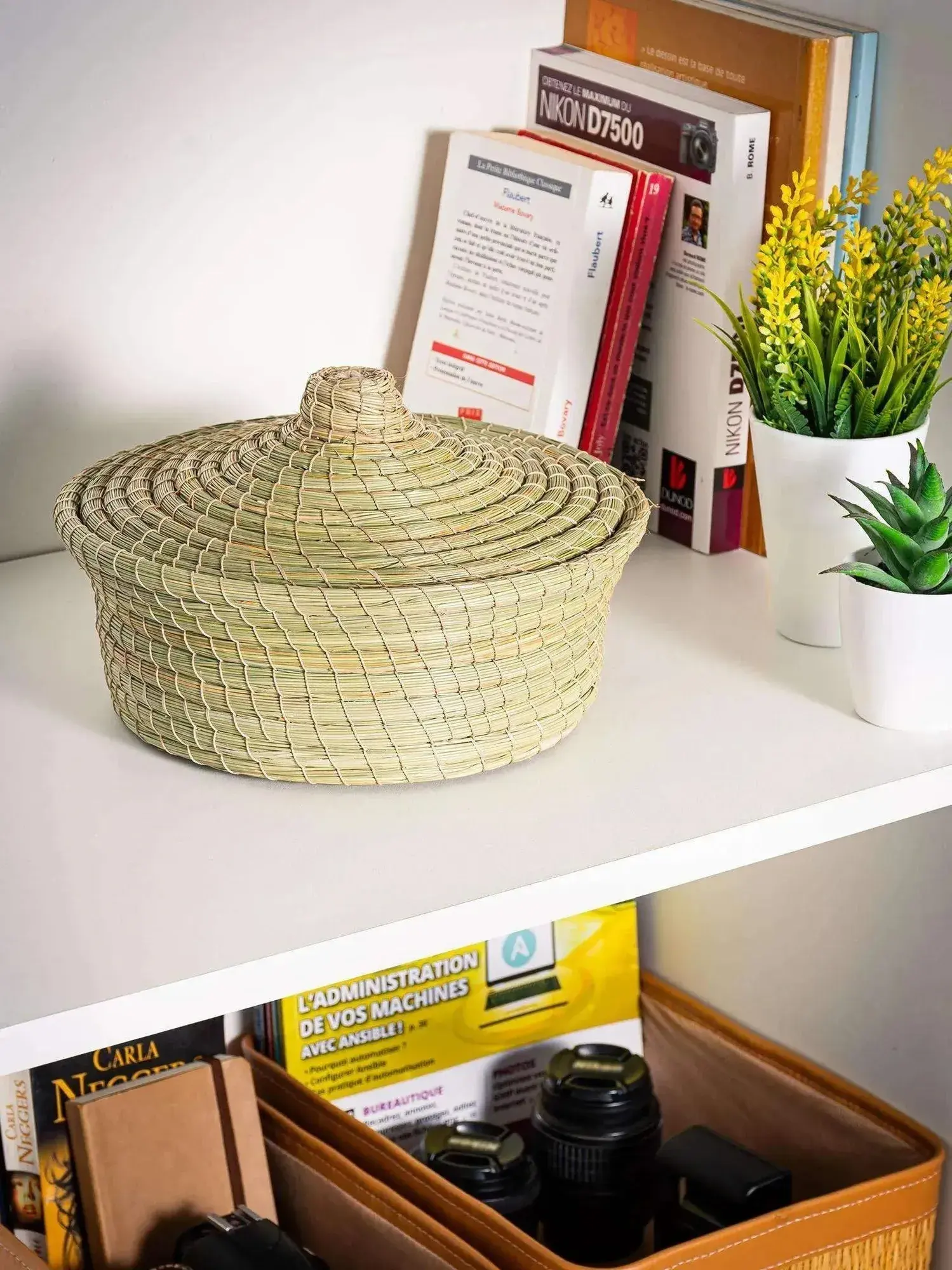 Round woven halfa basket with lid, natural darido fiber, decorative storage on shelf.