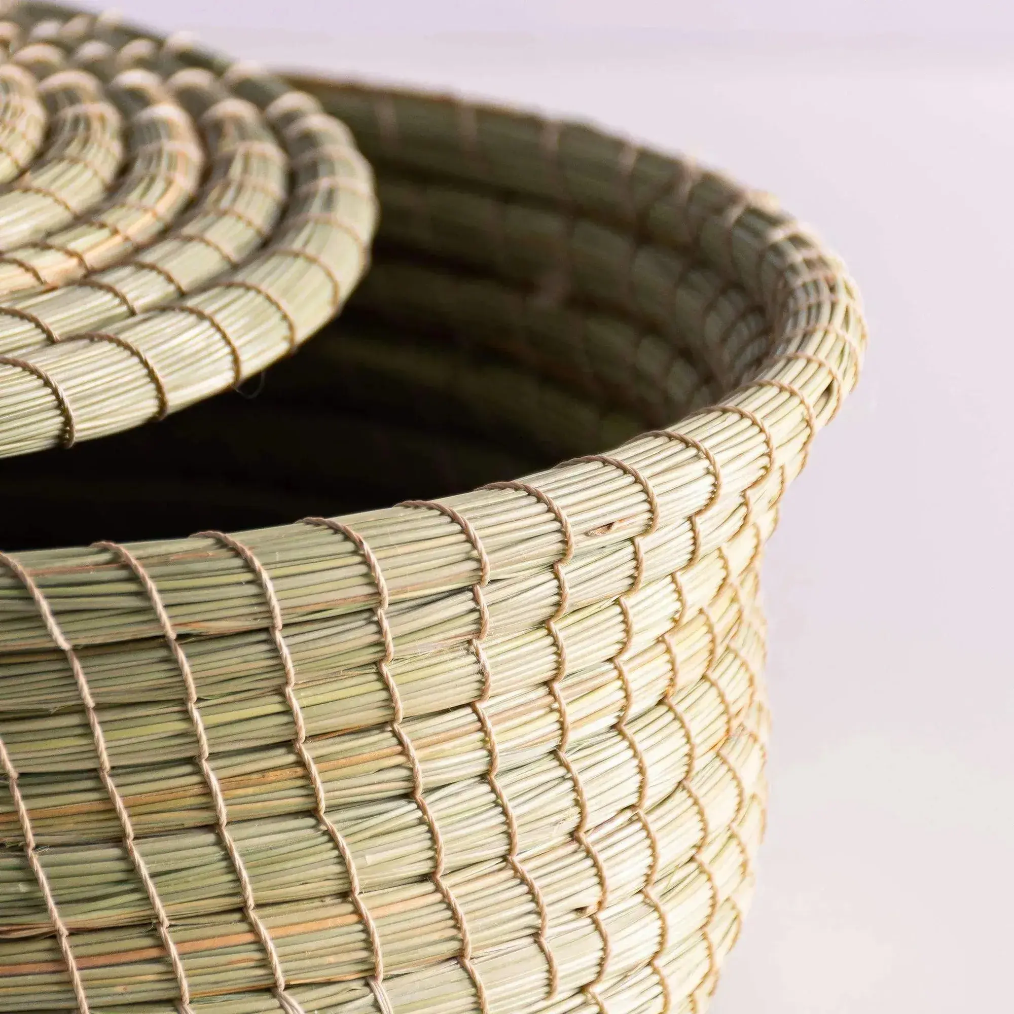 Close-up of light green woven darido halfa basket with textured detailed pattern.