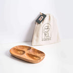 Handmade darido olive wood snack plate with 4 compartments next to branded cloth pouch. - Handmade Olive Wood Snack Plate – 4 Compartments | Elegant, Eco-Friendly & Unique