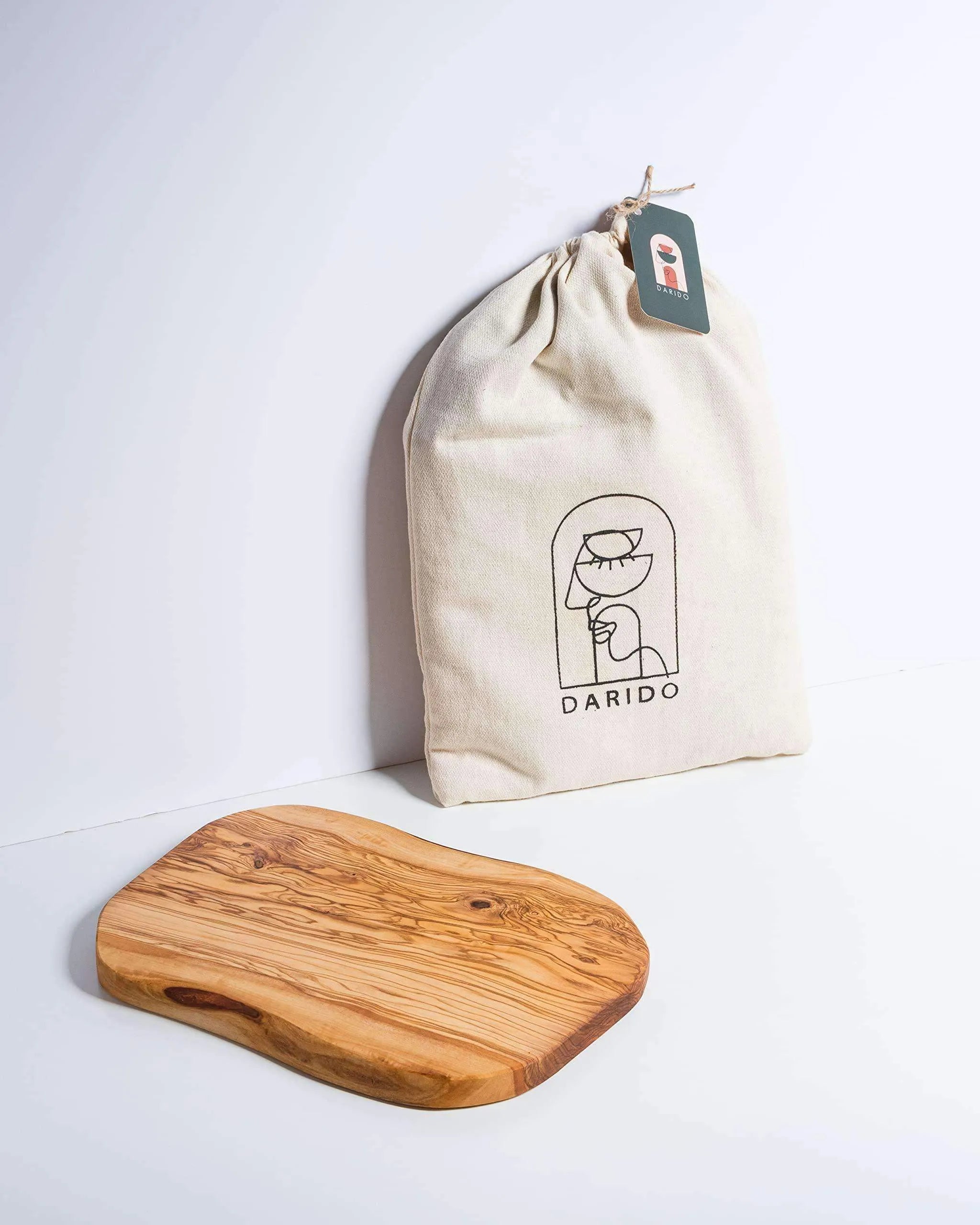 Rectangular handmade olive wood cutting board with rounded edges and natural grain, next to Darido branded cloth pouch. - Handmade Olive Wood Cutting Board – Reversible, Rustic & Food-Safe | 12x7" (30x18cm)