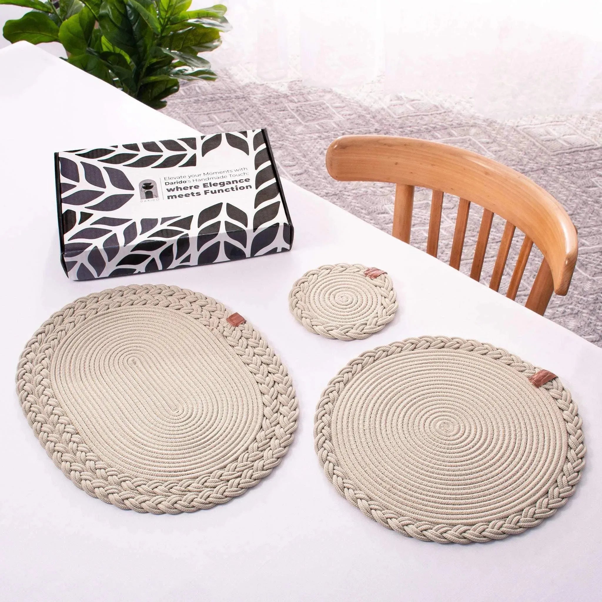 Set of 2 beige Darido cotton coasters with braided edges, one large and one small on white tabletop. - Set of 2 Beige Coasters - 15cm