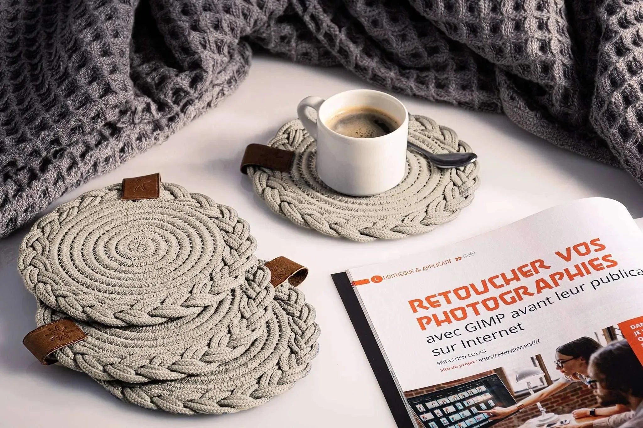 Set of 2 beige cotton Darido coasters with spiral design holding a cup of coffee on a tabletop. - Set of 2 Beige Coasters - 15cm