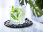 Set of 2 black cotton Darido coasters with intricate braided design under a glass of lime and mint drink. - Set of 2 Black Coasters- 15cm