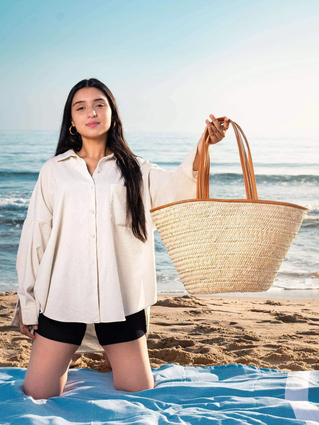 Large woven darido shopping bag with tan leather handles held on a sunny beach. - Shopping Bag Saaf with Leather L