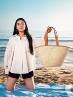 Large woven darido shopping bag with tan leather handles held on a sunny beach. - Shopping Bag Saaf with Leather L