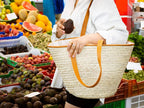 Woven darido shopping bag Saaf with tan leather handles held by woman at market. - Shopping Bag Saaf with Leather L