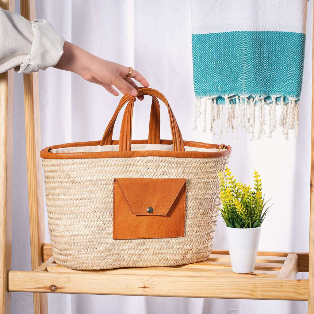 Darido woven shopping bag with tan leather pocket and handles on wooden table. - Shopping Bag Saaf with Leather Pocket M